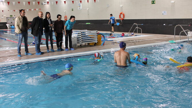 Autoridades en la piscina con alumnos del colegio de María.