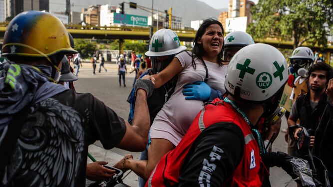 Personal médico auxilia a una persona afectada por los gases lacrimógenos durante el "trancazo" del lunes en Caracas.
