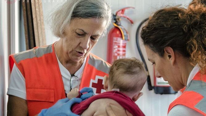 Voluntarios de Cruz Roja con la bebé.