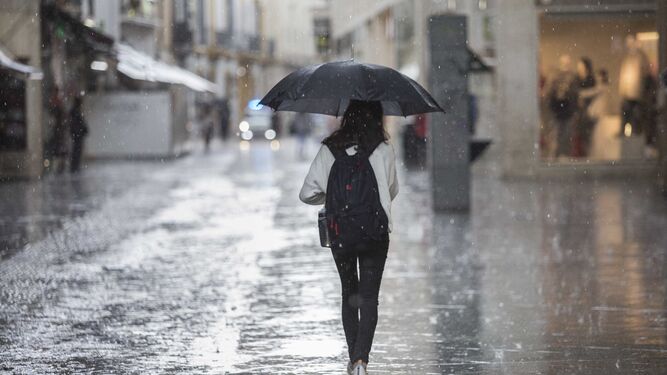 Una joven camina por la calle Velázquez en medio de una gran tormenta