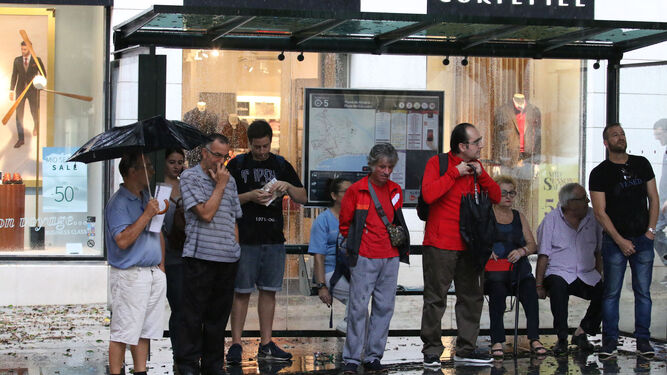 La gente se refugió de la lluvia en comercios, bares y en paradas de autobús.
