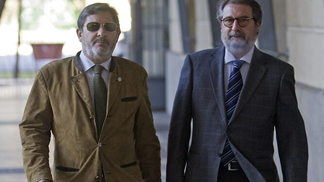 El ex director de Trabajo Javier Guerrero -izqda.- y su abogado, Fernando de Pablo, en los juzgados de Sevilla.