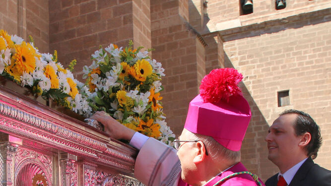 El obispo levanta a la imagen nada más salir a la plaza de la Catedral.