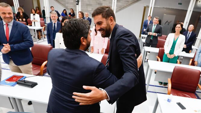 El presidente de Vox en la Región de Murcia, y diputado en la Asamblea, José Ángel Antelo, y el candidato del Partido Popular para presidir Murcia, Fernando López Miras, se abrazan tras la investidura.