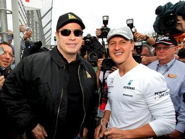El actor John Travolta posa con Schumacher antes del inicio de la carrera.