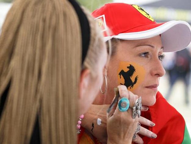 Dos chicas se pintan con el s&iacute;mbolo de Ferrari. (FOTOS: AFP/Reuters/EFE)