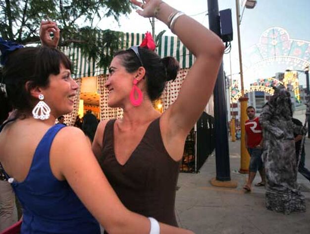 Dos j&oacute;venes bailando en una de las calles del Real de la Feria

Foto: J.M.Q.
