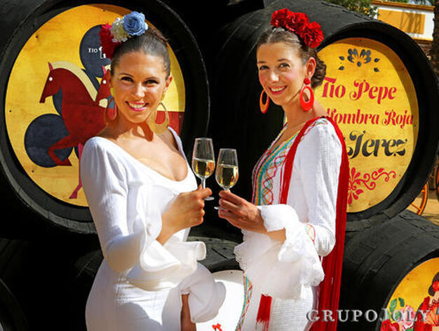 Dos j&oacute;venes brindan por la Feria junto a botas de T&iacute;o Pepe. 

Foto: Pascual