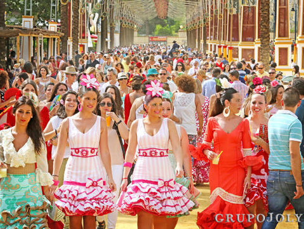 Varias j&oacute;venes pasean por un Real a rebosar vestidas de flamencas.

Foto: Pascual