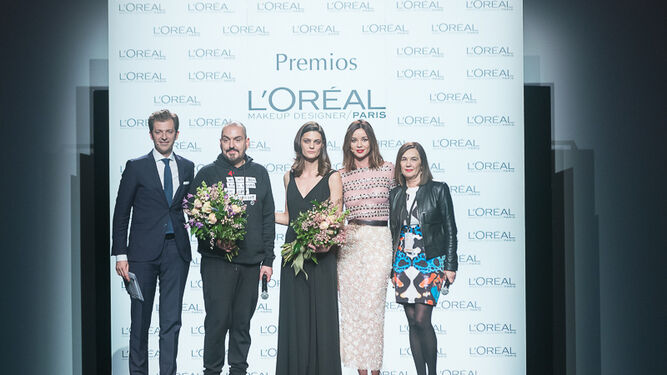 Juan Duyos y Marina Pérez, ambos con ramos de flores, recogen el premio L'Oreal de este año.