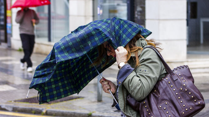 Una mujer intenta protegerse del aire y del viento de estos últimos días.