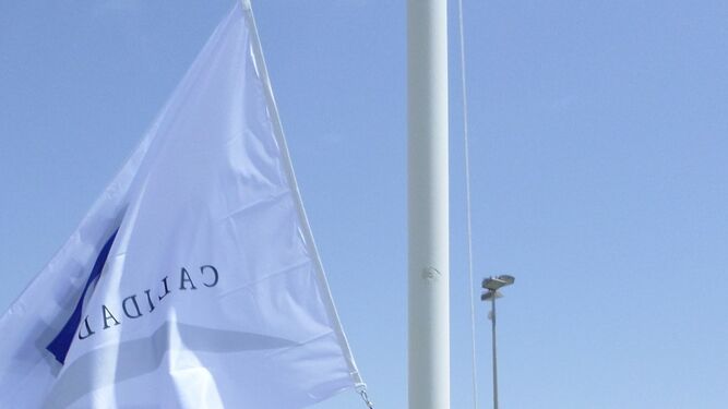 Izado de una de las banderas, ayer en la Urbanización de Roquetas de Mar.