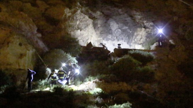Bomberos y policías sacan los cuerpos de los jóvenes de la casa cueva de La Molineta.