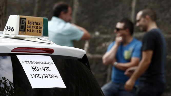 Un taxi de Pamplona con carteles contra la actividad de los vehículos de alquiler con conductor.