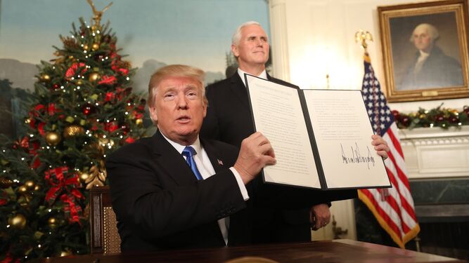 Donald Trump firma su proclamación en la sala de recepciones diplomáticas de la Casa Blanca ante el vicepresidente, Mike Pence, ayer en Washington.