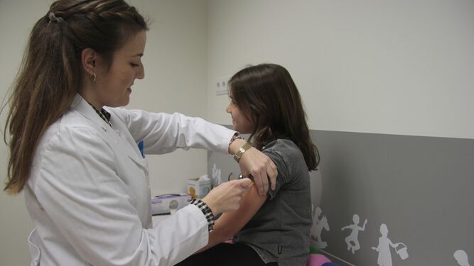 Una enfermera administra una vacuna durante una consulta.