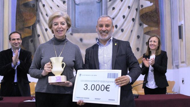 El alcalde de Vera, Félix López entrega el cheque con 3.000 euros a la ganadora del premio de poesía.