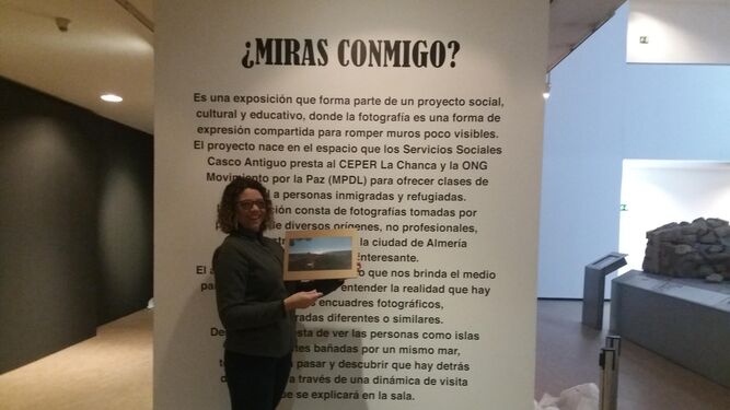 María Moura con el cartel explicativo dela exposición.