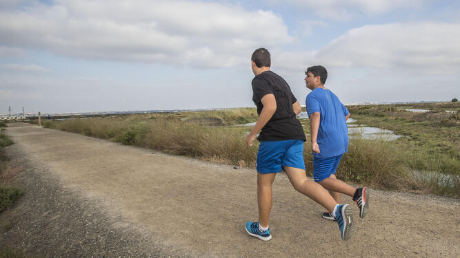 Dos jóvenes practicando deporte por el sendero del Carrascón, desde donde partirá el nuevo nuevo camino para peatones y ciclistas hacia Chiclana.