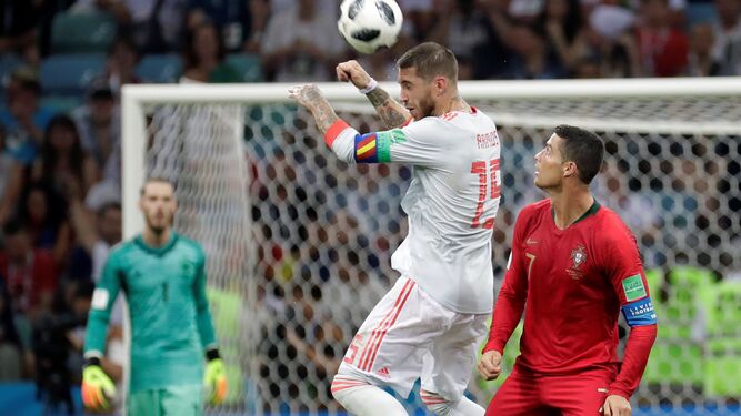Sergio Ramos le gana un balón aéreo a Cristiano Ronaldo ante la mirada lejana de De Gea