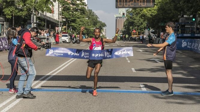 Gizaw Bekele levanta los brazos tras cruzar la línea de meta en la media maratón de Madrid.
