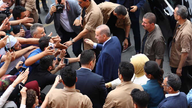 El reelegido presidente turco Recep Tayyip Erdogan recibe la aclamación de sus simpatizantes después de acudir a votar en un colegio electoral de Estambul.