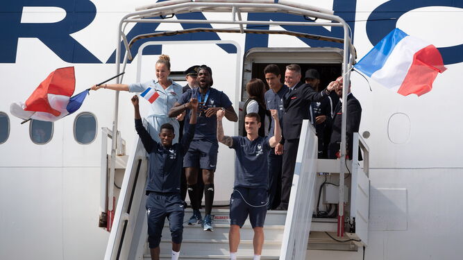 Los jugadores franceses bajan del avión para ofrecer el título mundial a sus aficionados.