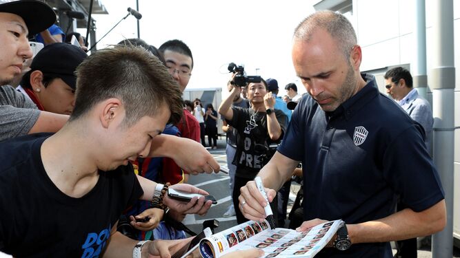 Iniesta firma autógrafos a su llegada al aeropuerto de Kansai, en Osaka.