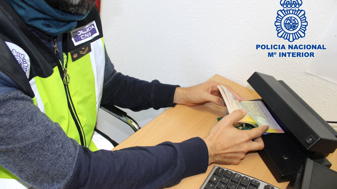 Un agente estudia uno de los pasaportes intervenidos durante la operación Fragua.