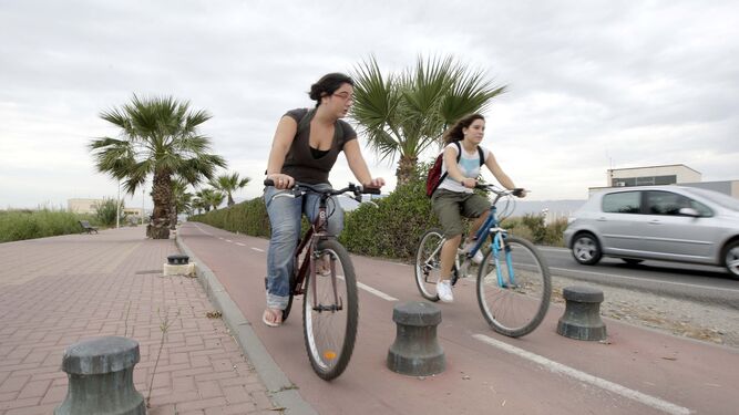 Dos estudiantes universitarias recorren en bicicleta el camino de Ribera de la Universidad de Almeria.