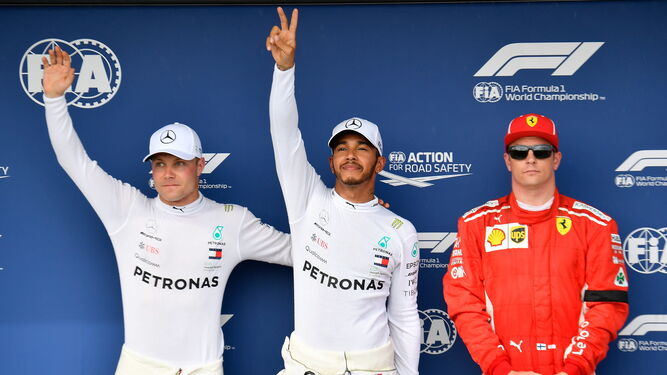 Hamilton celebra la 'pole' junto a su compañero Bottas y Kimi Raikkonen.