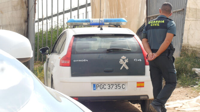 Un agente del equipo ROCA junto al coche de la Guardia Civil.