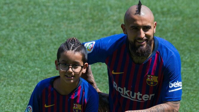 Arturo Vidal posa junto a su hijo Alonso en el césped del Camp Nou durante su presentación.