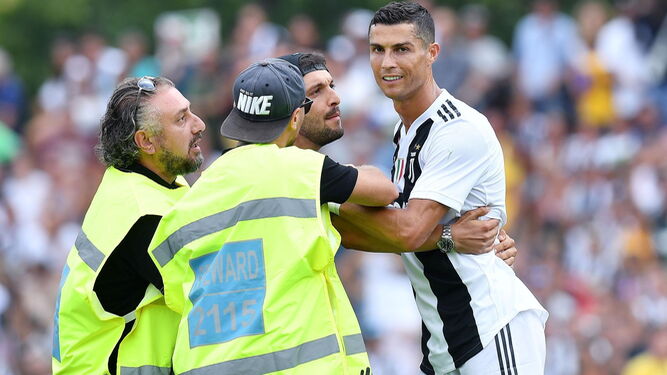 Cristiano Ronaldo es abrazado por un espontáneo en el partido de su debut.