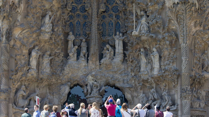 Un grupo de turistas  contemplando el templo de la Sagrada  Familia  en Barcelona.