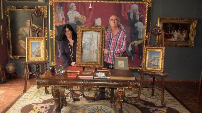 Carmen Muñoz y Manuel Vida en el salón de su casa, junto a tres de las obras sobre Venecia que se mostraran en el Espacio 2 del Museo de Arte de Almería.