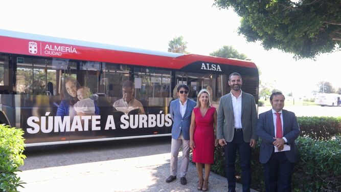 El director de Surbús, el alcalde, la vicerrectora y el concejal de Movilidad junto al autobús con campaña promocional.