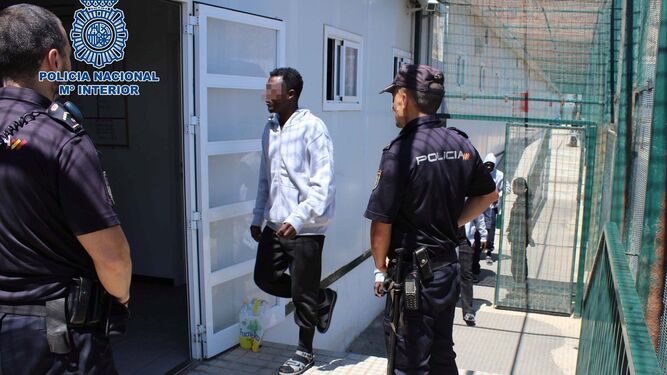 Agentes de la Policía Nacional custodian a los inmigrantes rescatados de pateras durante su llegada a los módulos del puerto pesquero de Almería.