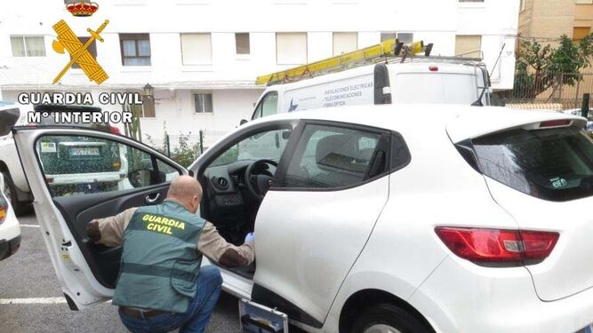 Un agente de la Guardia Civil toma muestras del vehículo sustraído en Garrucha.