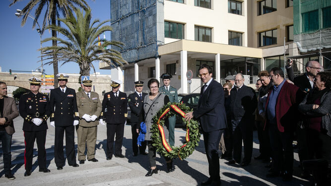 El alcalde y una representante de la asociación Arrabal de Puntales con la corona de flores que depositaron a los pies del monumento a la Constitución.