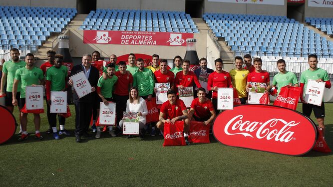 Lorena García, responsable de organización, posa con los jugadores y responsables de Coca Cola con el calendario para 2019