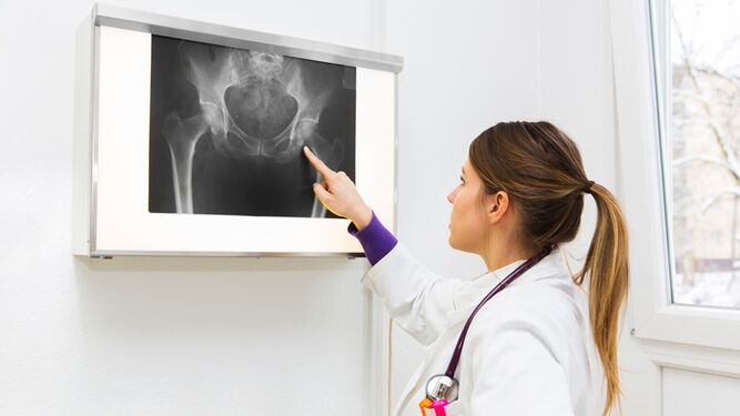 Una doctora examina una radiografía.