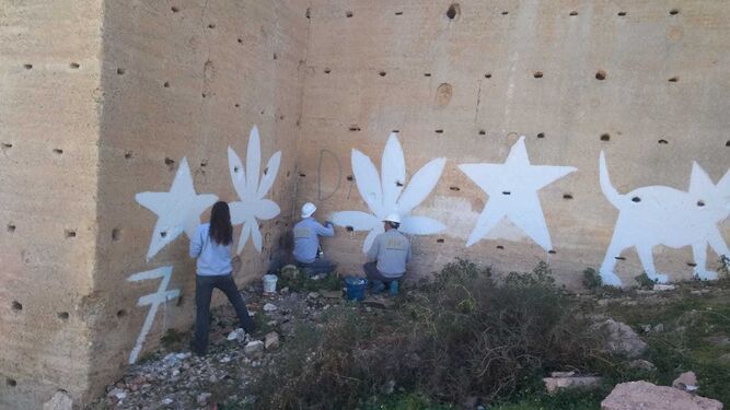 Varios trabajadores eliminan las pintadas de las Murallas del Cerro de San Cristóbal
