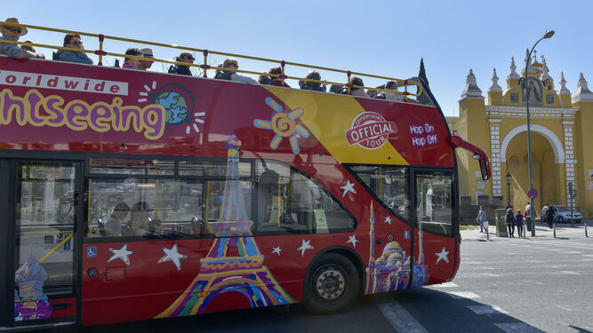 Un autobús turístico pasa por delante de la Muralla de la Macarena.