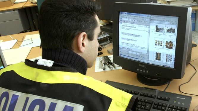 Un agente policial observa datos de internet en una web.