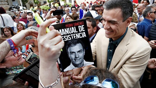 Pedro Sánchez firmando un ejemplar de su libro tras un acto político en la Plaza del Vinculo de Pamplona el pasado 15 de mayo.