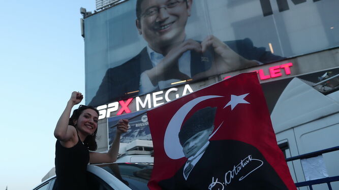 Una simpatizante socialista celebra el triunfo de Ekrem Imamoglu, que aparece en el cartel.