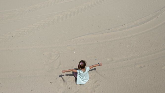 Una niña juega con la arena de la playa de Getares, en Algeciras.