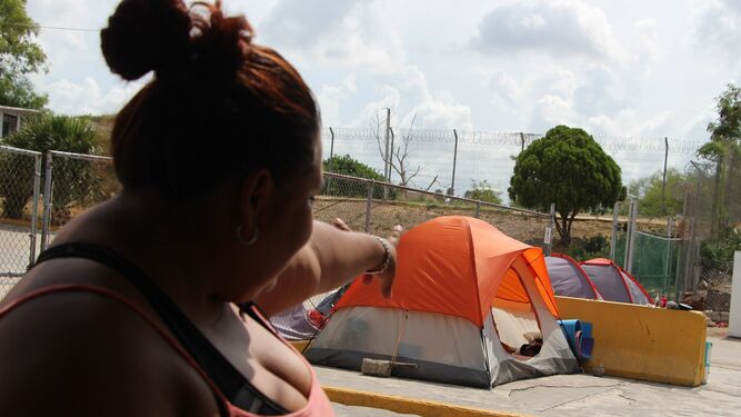 Un mujer muestra las tiendas de campaña donde esperan algunos migrantes en la mexicana Matamoros.