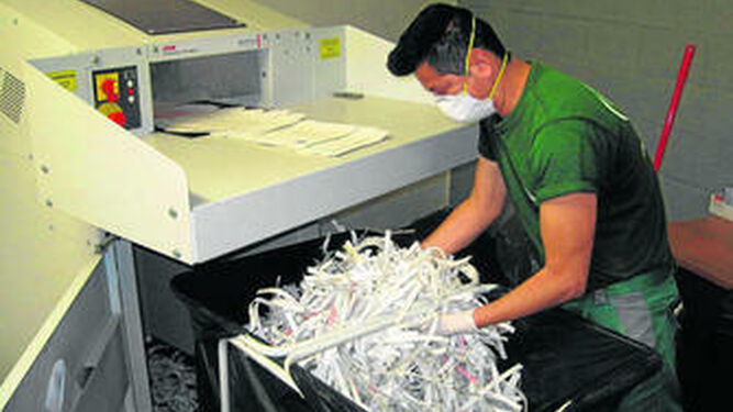 Un trabajador durante la destrucción de documentos.